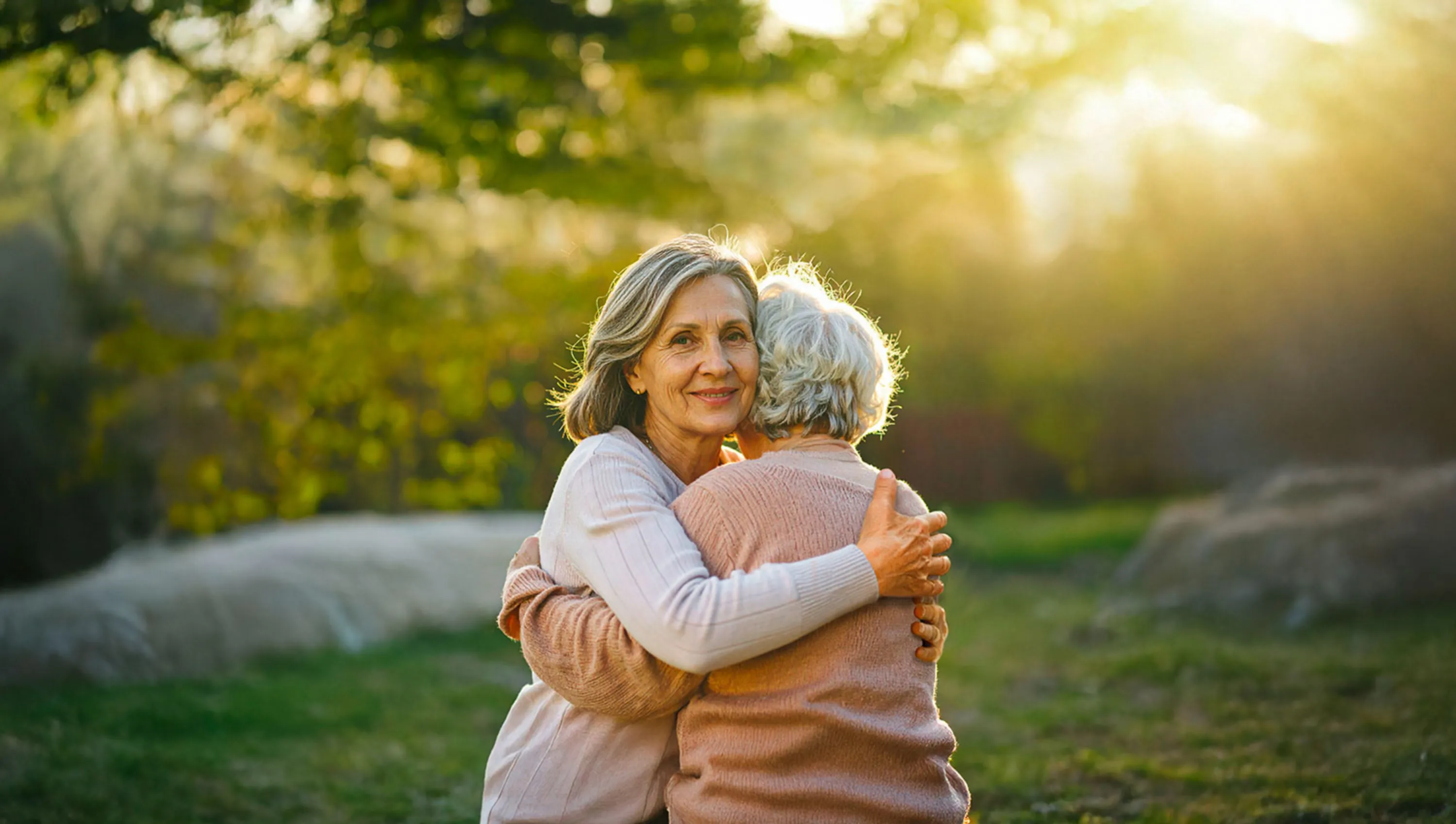 Eine ältere Tochter umarmt ihre betagte Mutter